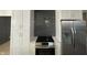 White shaker cabinets, dark gray tile backsplash, and stainless steel appliances at 454 Tulip Dr, Mooresville, IN 46158