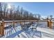 Snow-covered deck with metal table and chairs, overlooking a snowy backyard at 6361 Crystal Springs Dr, Avon, IN 46123