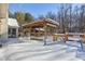 Wooden deck covered in snow, featuring a pergola and access to a backyard at 6361 Crystal Springs Dr, Avon, IN 46123