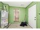 Basement featuring concrete walls and flooring, a water heater, and access to other rooms at 715 N Warman Ave, Indianapolis, IN 46222