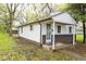 Home exterior showing a cozy covered porch, white siding, and a small storage shed at 715 N Warman Ave, Indianapolis, IN 46222