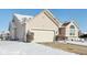 Side view of beige house, white garage door, snowy landscape at 870 Harvest Lake Dr, Brownsburg, IN 46112