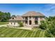Stately tan two-story home boasts stone accents, manicured lawn, and beautiful landscaping at 1023 Westview Point Dr, Columbus, IN 47201