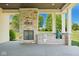 Covered outdoor kitchen with stone fireplace, grill, and views of the backyard at 1023 Westview Point Dr, Columbus, IN 47201