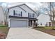 Two-story house with gray siding, brick accents, and a long driveway at 1127 Maple Stream Dr, Indianapolis, IN 46217