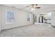 Open living room with ceiling fan, grey carpet and kitchen access at 1127 Maple Stream Dr, Indianapolis, IN 46217