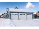 Three-car garage with white doors and snow-covered driveway at 13139 Broad St, Carmel, IN 46032