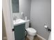 Small basement bathroom with teal vanity and toilet at 1513 Laurel Dr, Columbus, IN 47203