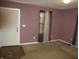 Mauve walls and carpeted floor in this bedroom with a window and door at 317 N Bradley Ave, Indianapolis, IN 46201