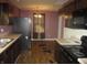 Kitchen with dark brown cabinets, and damaged flooring at 317 N Bradley Ave, Indianapolis, IN 46201