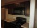 Dark brown cabinets and black appliances in this kitchen at 317 N Bradley Ave, Indianapolis, IN 46201