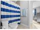 Bright bathroom with a shower featuring a blue and white striped curtain and towel rack at 78 Chatham Brook Dr, Westfield, IN 46074