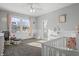 Light-filled bedroom with a crib, rocking chair, and wainscoting at 78 Chatham Brook Dr, Westfield, IN 46074