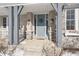 Brick front porch with rocking chairs and stylish blue front door at 78 Chatham Brook Dr, Westfield, IN 46074