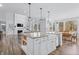 Open kitchen features a large island with seating, white cabinets, and a farmhouse sink at 78 Chatham Brook Dr, Westfield, IN 46074