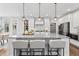 Modern kitchen featuring a large granite island with seating, pendant lights, and sleek white cabinets at 78 Chatham Brook Dr, Westfield, IN 46074