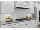 Close up of kitchen cook top with stylish herringbone backsplash, granite counter, and white cabinets at 78 Chatham Brook Dr, Westfield, IN 46074
