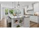 Bright kitchen with a large center island featuring pendant lighting and seating overlooking the backyard at 78 Chatham Brook Dr, Westfield, IN 46074