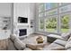 Bright living room boasts fireplace, built-ins, and large windows overlooking the landscaped yard at 78 Chatham Brook Dr, Westfield, IN 46074