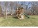 Backyard wooden playset with swings, slide, climbing structure, and ladder on a grassy lawn surrounded by trees at 78 Chatham Brook Dr, Westfield, IN 46074