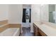 This bathroom features a tub, wood-look floors, window, and a wood vanity with solid surface countertop at 7906 Hampton Pl, Fishers, IN 46038