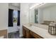 Bathroom featuring a window with dark curtains, vanity, large mirror, and bright vanity lights at 7906 Hampton Pl, Fishers, IN 46038