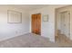 Bright bedroom featuring neutral carpet, fresh white walls, natural lighting, and a wooden door at 7906 Hampton Pl, Fishers, IN 46038