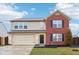 Two-story brick and beige home with a two-car garage and landscaped lawn at 7988 Kersey Dr, Indianapolis, IN 46236