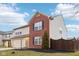 Two-story home with red brick and beige vinyl siding, a two-car garage, and a fenced yard at 7988 Kersey Dr, Indianapolis, IN 46236