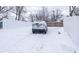 Snowy backyard with a car parked in the driveway at 1601 Spruce St, Indianapolis, IN 46203