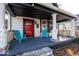 Inviting front porch with teal chairs and a red front door at 1601 Spruce St, Indianapolis, IN 46203