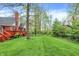 A spacious backyard with a deck overlooking the lush landscaping and mature trees at 1398 Penny Ln, Greenfield, IN 46140