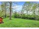 Expansive backyard featuring a large green lawn and mature trees providing shade and privacy at 1398 Penny Ln, Greenfield, IN 46140
