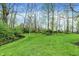 Lush green backyard with a stream, creating a peaceful and natural setting for relaxation and enjoyment at 1398 Penny Ln, Greenfield, IN 46140