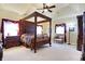 Main bedroom with four-poster bed, sitting area, and ample natural light at 1398 Penny Ln, Greenfield, IN 46140