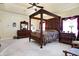 Main bedroom with large four-poster bed, dresser, and carpeted floor at 1398 Penny Ln, Greenfield, IN 46140