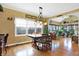 Bright dining room with a farmhouse table and sunroom access at 1398 Penny Ln, Greenfield, IN 46140