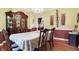 Bright dining room with a large table, hardwood floors, and a built-in hutch at 1398 Penny Ln, Greenfield, IN 46140