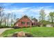 Expansive lush lawn surrounds this two-story brick home, accented by mature trees and meticulous landscaping at 1398 Penny Ln, Greenfield, IN 46140