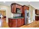 Spacious kitchen with dark cabinetry, stainless steel appliances, and hardwood flooring at 1398 Penny Ln, Greenfield, IN 46140