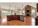 Open concept kitchen with island, stainless steel appliances, and stone fireplace at 1398 Penny Ln, Greenfield, IN 46140