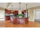 Elegant kitchen with dark wood cabinets, island, stainless steel appliances, and hardwood floors at 1398 Penny Ln, Greenfield, IN 46140