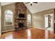 Vaulted living room featuring a stone fireplace, hardwood floors, and entry to another room at 1398 Penny Ln, Greenfield, IN 46140