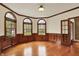 Bright living room with wood floors, arched windows, detailed molding, and custom wood paneling at 1398 Penny Ln, Greenfield, IN 46140