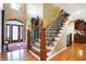 Elegant wooden staircase with wrought iron railing in the entryway at 1398 Penny Ln, Greenfield, IN 46140