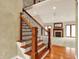 Elegant staircase with decorative wood railings and a view into the spacious living room with fireplace at 1398 Penny Ln, Greenfield, IN 46140