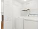 Functional laundry room with modern washer and dryer units and shelving for storage at 14944 Mia Dr, Carmel, IN 46033
