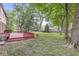 Spacious backyard with a red deck, mature trees, and well-kept lawn at 409 Lansdowne Rd, Indianapolis, IN 46234