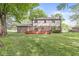 Spacious backyard featuring a charming two-story house with a well-maintained lawn and a large red deck at 409 Lansdowne Rd, Indianapolis, IN 46234