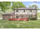 Expansive backyard view showcasing a two-story home with a large red deck and lush green lawn at 409 Lansdowne Rd, Indianapolis, IN 46234